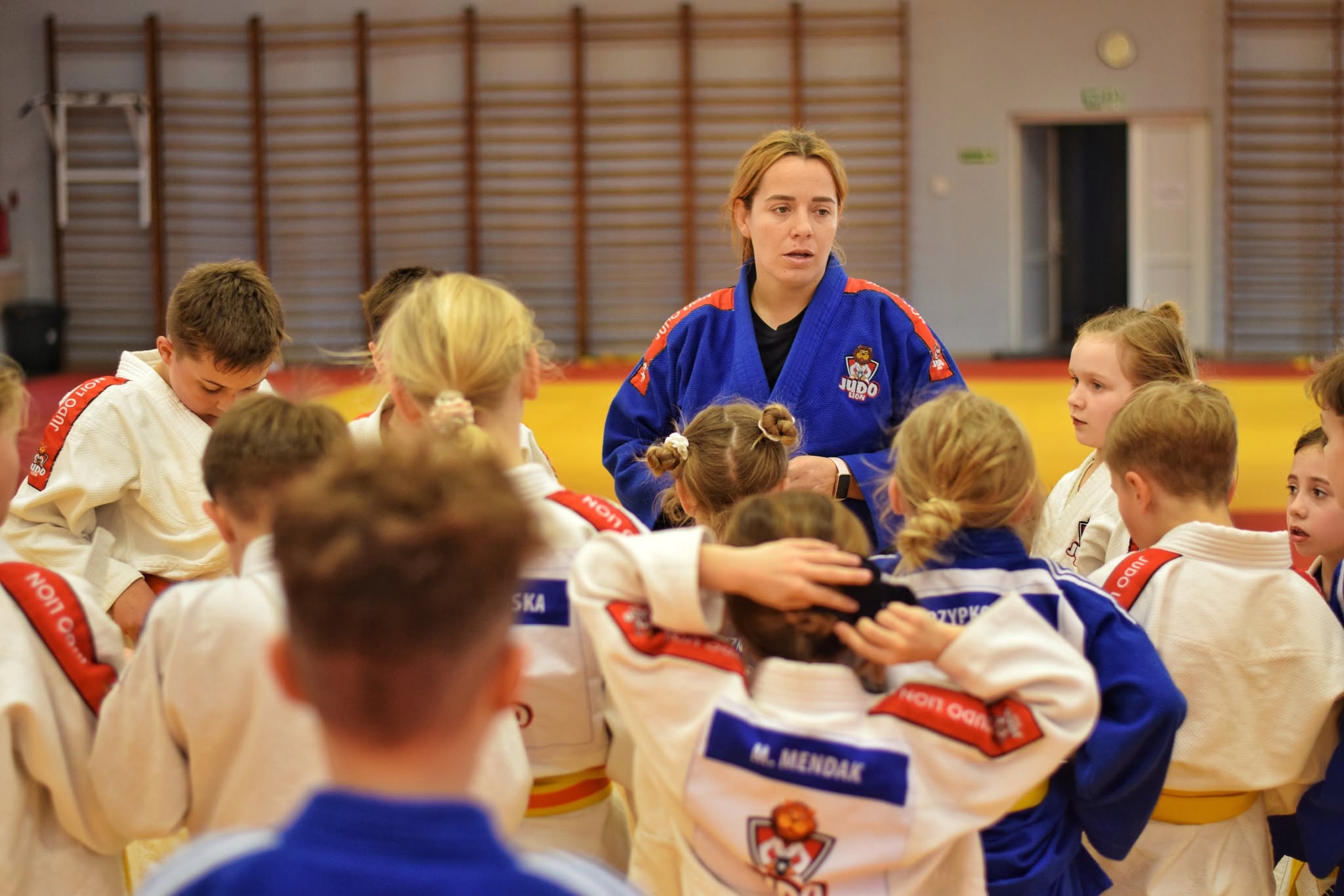 Trenerka i dzieci UKS Judo Lion podczas wspólnego treningu